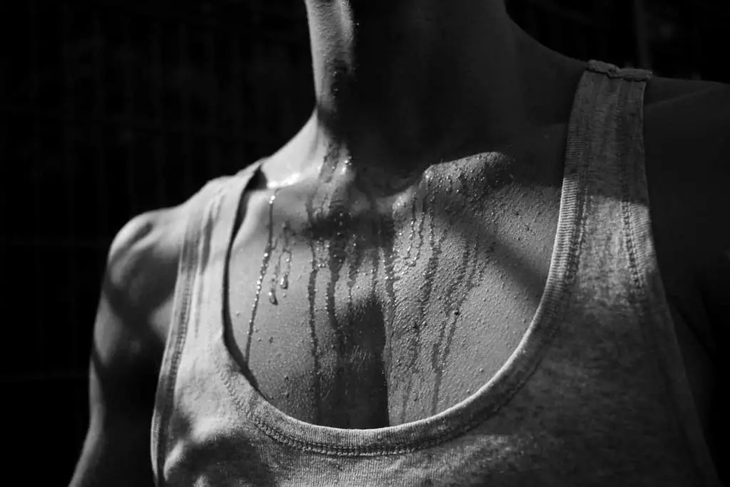 a man sweating a lot that the sweat running from his neck down to his chest