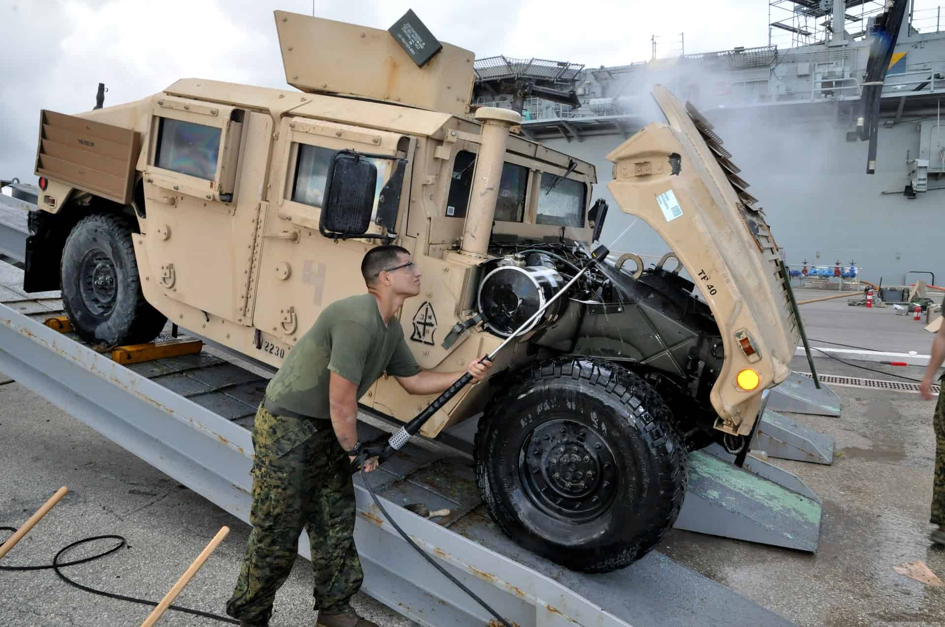 MILITARY GUY cleaning a military vehicle using a pressure washer