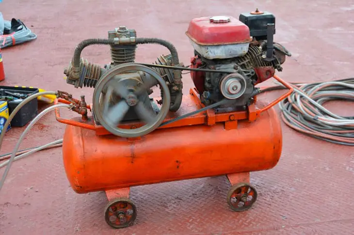 the orange air compressor using for the tire in car
